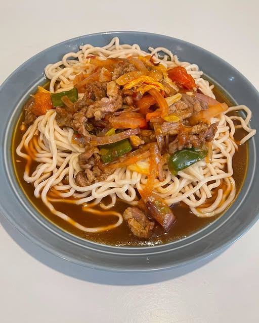Lamian noodles topped with beef, tomato and peppers in a savoury sauce