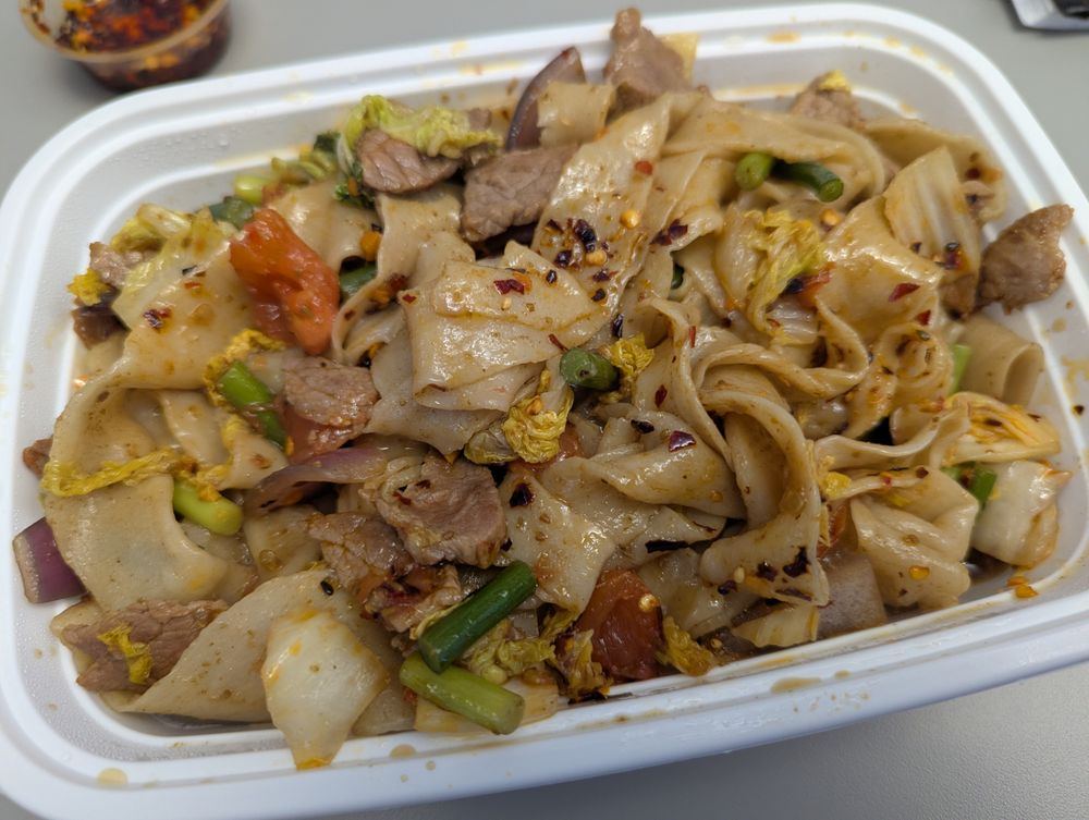Xinjiang-style wide hand-pulled noodles stir-fried with beef, cabbage, peppers and chili